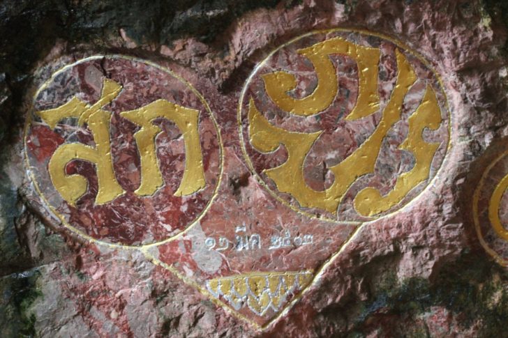 พระปรมาภิไธยย่อ &nbsp;&ldquo;ภปร.&rdquo; และ &ldquo;สก.&rdquo; บนผนังถ้ำ วัดสุวรรณคูหา